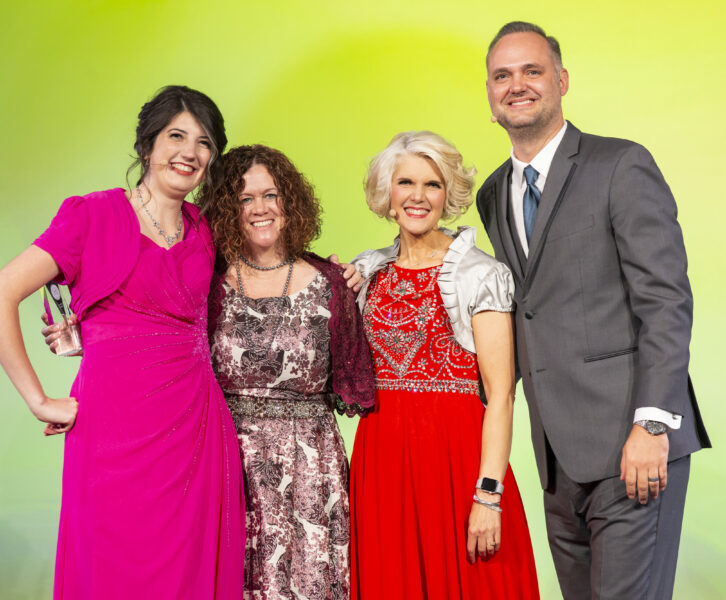 About Me image showing Jill Hagner accepting an award on stage at ChalkCon Dallas 2019.