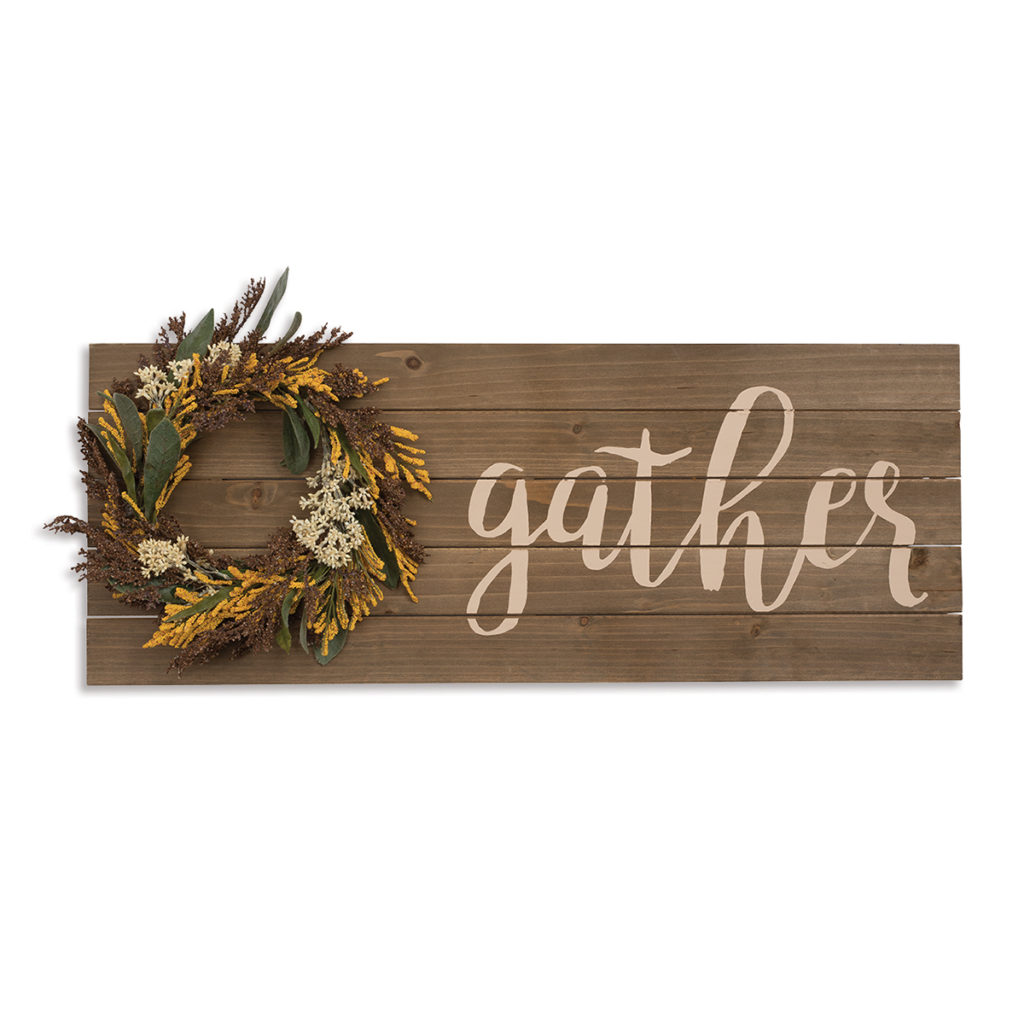 Wooden slats with fall wreath and the word "gather" chalked on it.