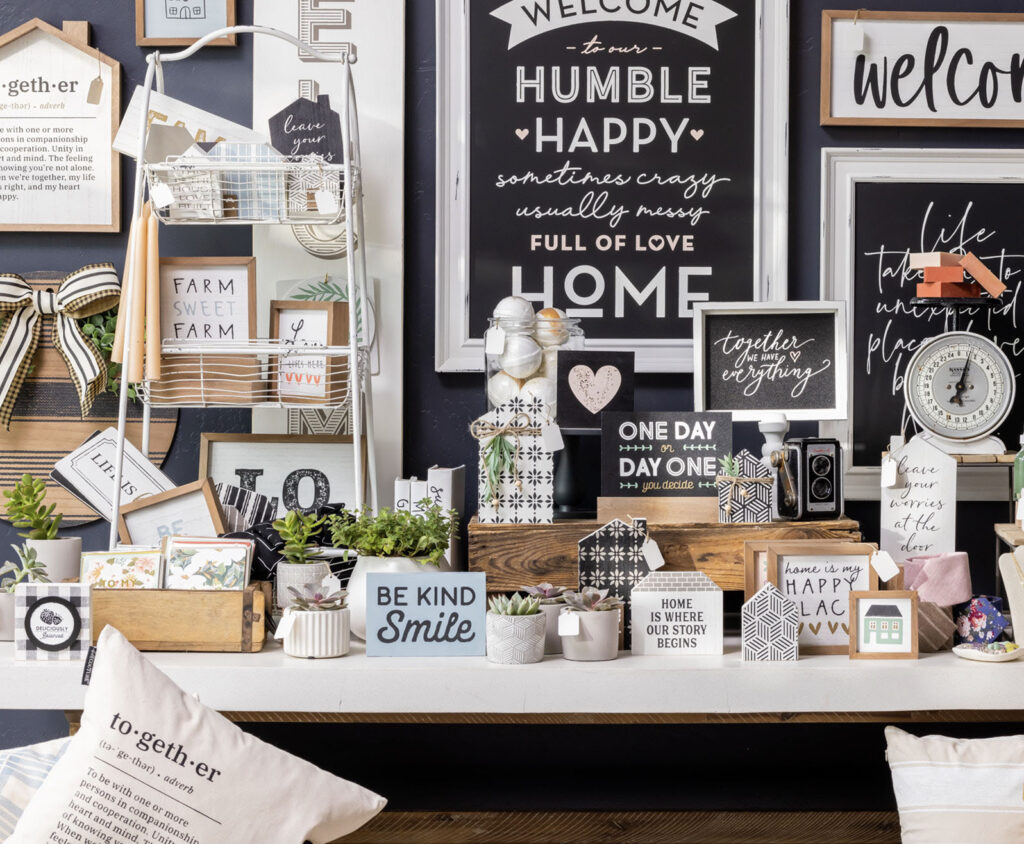 A gorgeous display with a console table and wall covered with artful signs showing creative text and sayings.